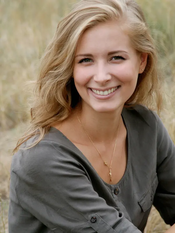 Lächelnde Frau mit blonden Haaren in einem Feld